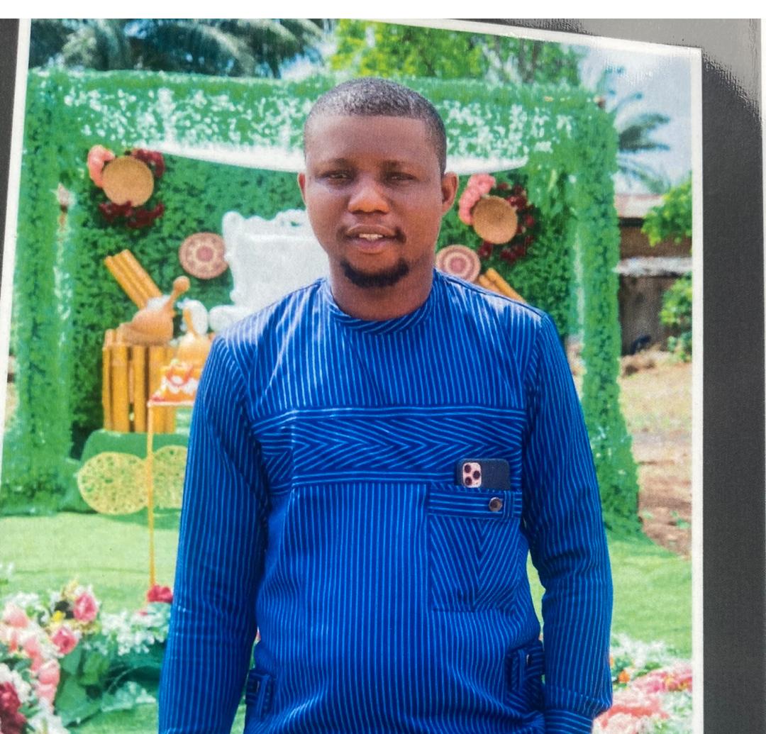 Samuel Ibuadimma smiling warmly in a business casual outfit, seated in a well-lit office environment. The mood is positive and confident, suggesting satisfaction and trust.