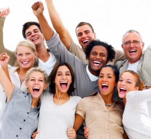 A group of smiling people standing together, appearing happy and engaged in a bright indoor setting. The environment suggests a positive and collaborative atmosphere. No visible text in the image.